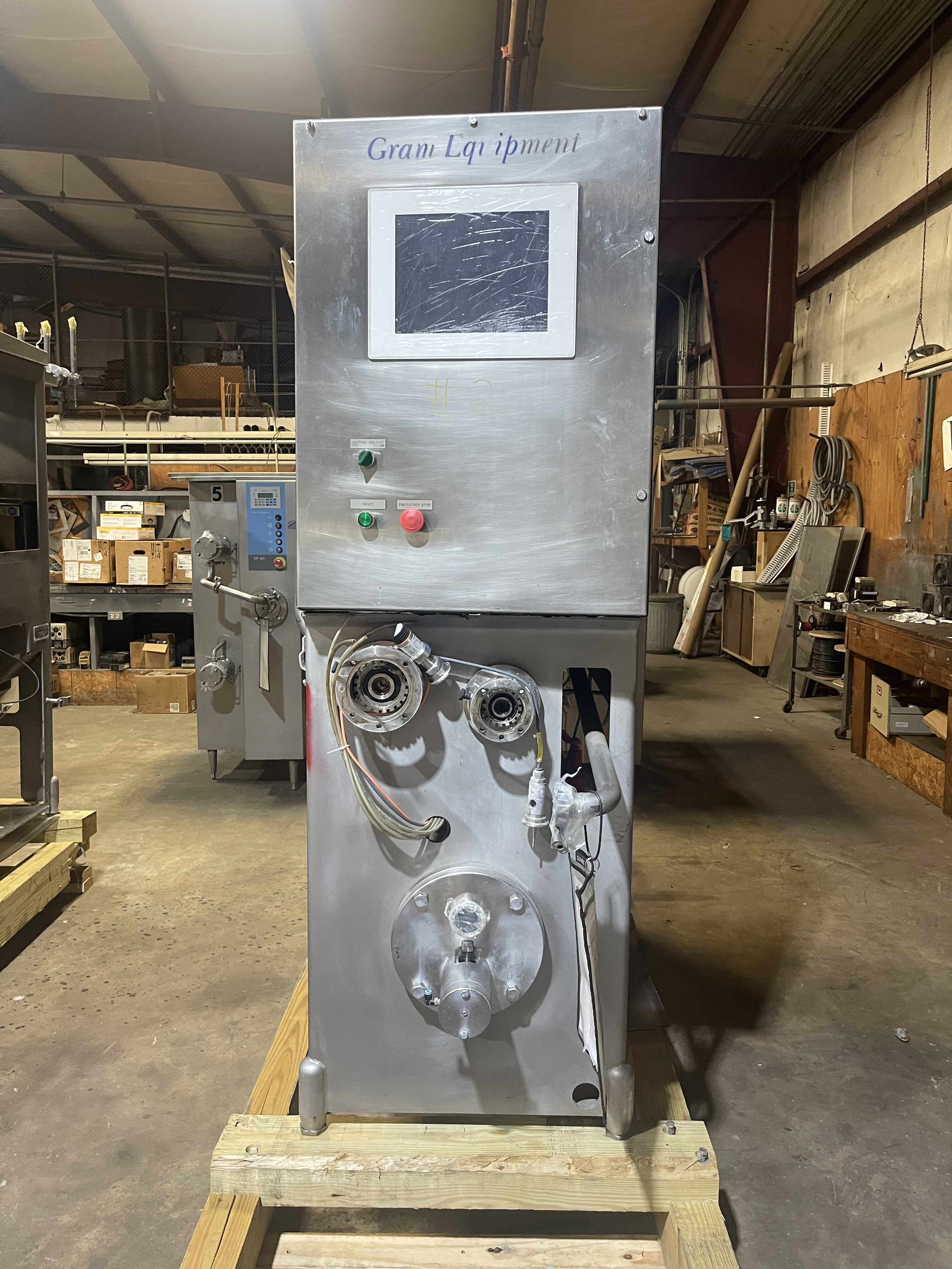 front view of an industrial ice cream machine sitting on a pallet.